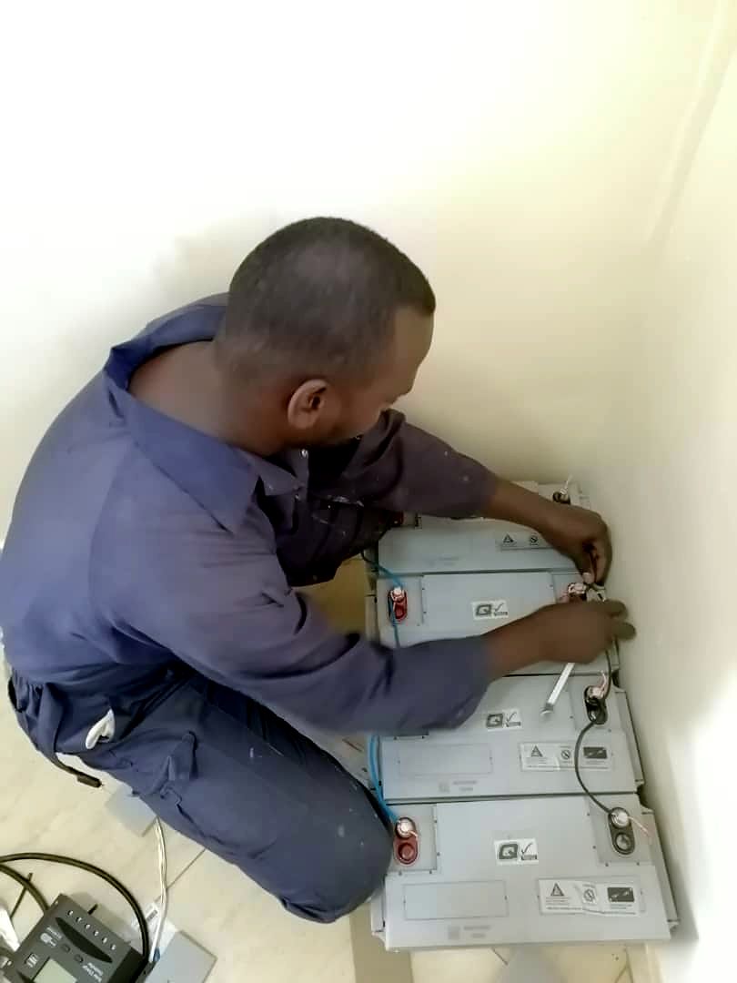 Technician connecting backup batteries on the floor