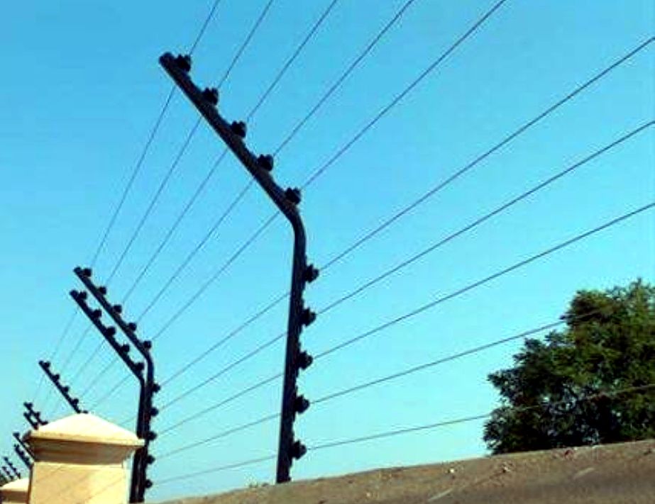 Electric fence posts and insulators installed on a wall