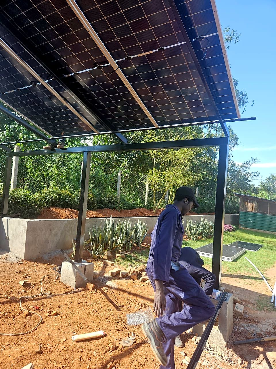 Technician working beneath a newly built solar carport