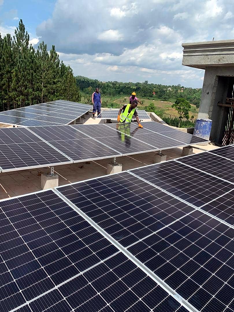Technicians working across a large flat-roof solar array