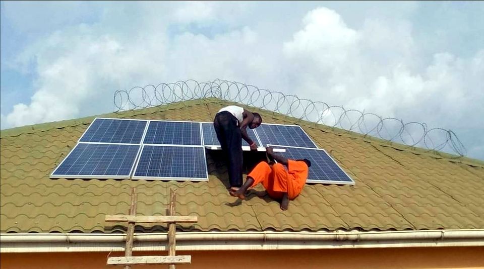Technician fitting solar panels on a corrugated roof