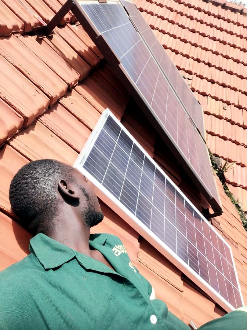 Technician checking a row of solar panels on a tiled roof